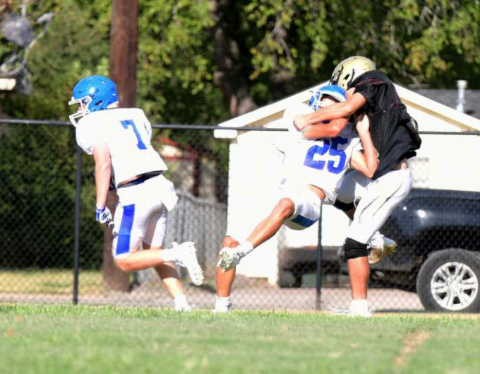 Klayton Chance (7) gets a key block from Cameron Cull (25) to score on a 42-yard pass from quarterback Andrew Steffek in the controlled part of the scrimmage Thursday. Chuck Grafe/Tribune-Herald