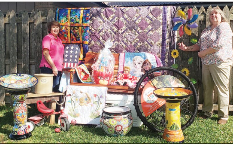 Moulton Easter Picnic auction chairpersons Lorrie Janecek and Mary Lou Dierschke display some of the fine items available Sunday at St. Joseph’s Social Center, part of the Catholic church’s annual Easter picnic in Moulton.