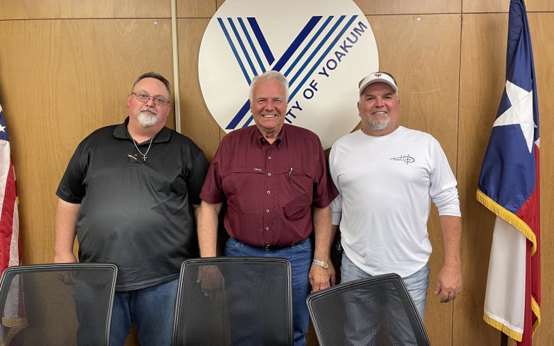 Councilmembers Michael Brandt and John Pelech pose with Yoakum Mayor Carl O’Neill after the meeting held Tuesday, May 10.