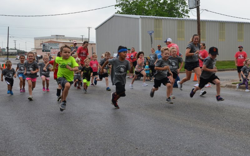 A mob of kids sprint to start the kid’s fun run on Saturday, May 7.