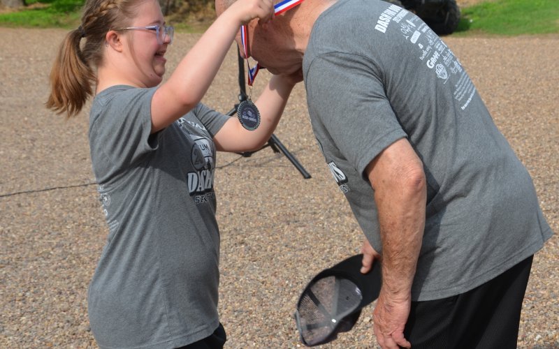 Macy Svec places a medal around James Leist’s neck during Saturday morning’s award ceremony.