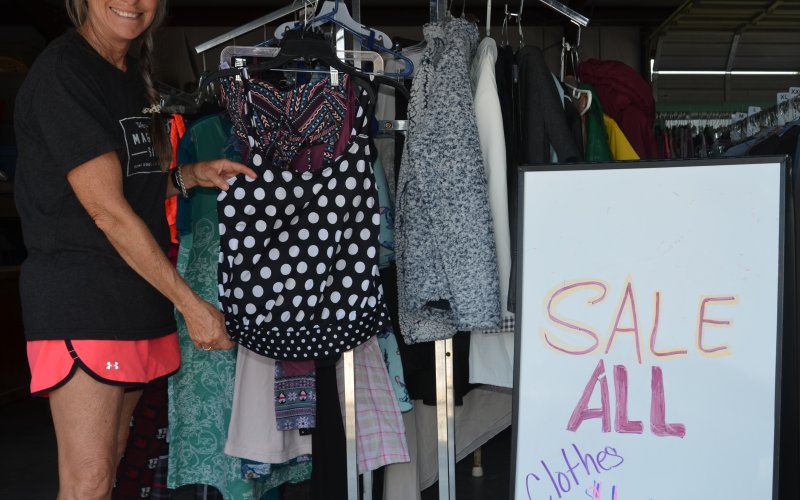 SNYPD Board Member Lisa Fowler displays one of the clothing items available for $1 at the SNYPD warehouse in Cuero.