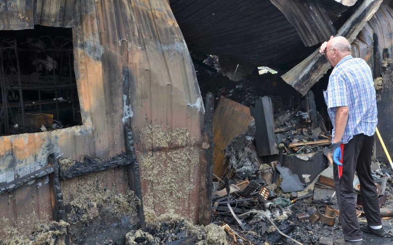 Joe F. Chandler Sr. peers into a scorched portion of The Cookie Jar on Sunday, May 22.