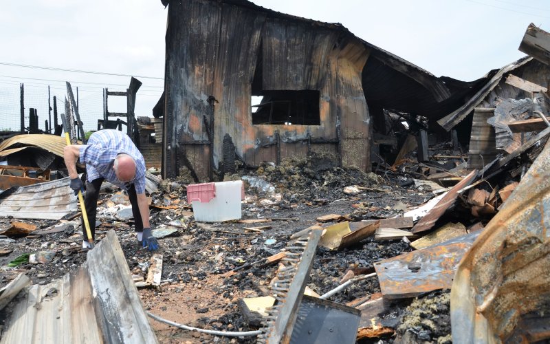 Joe F. Chandler Sr. scavenges the remains of the antique shop that he had managed for over ten years in search of salvageable items.