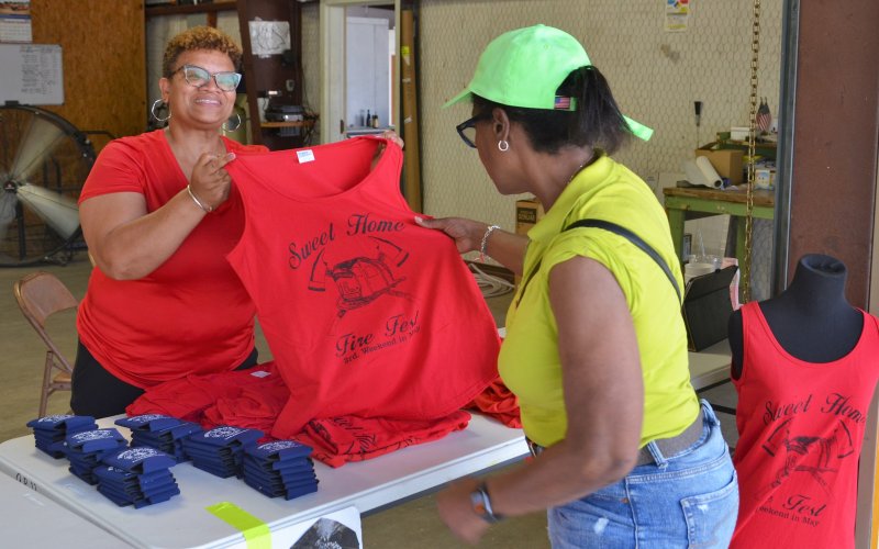 Memorie Huelett displays a shirt for Lula Lenzy at the Fireman’s Fest on May 21.