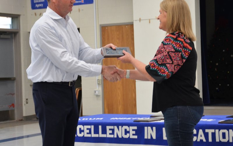 YISD Superintendent Tom Kelley congratulates Janet Jiral, nurse at the Yoakum Primary School for eight years.