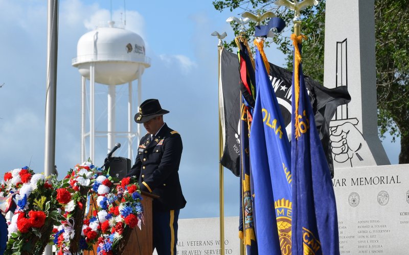 Operations Officer for the First Squadron, 112th Cavalry Regiment, Major Matt Machacek, pays his respects to fallen veterans during the Memorial Day Tribute at the Veterans War Memorial.