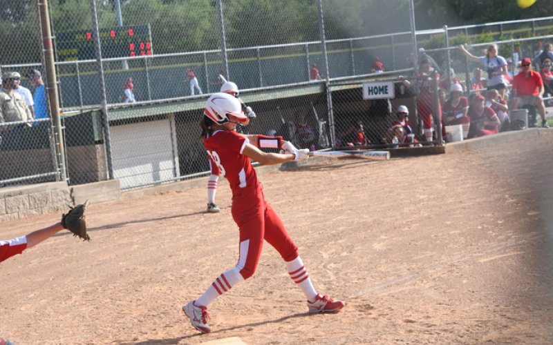 Ashlyn Pesek sends the ball high on one of her two home run hits. Photo by Mark Lube.