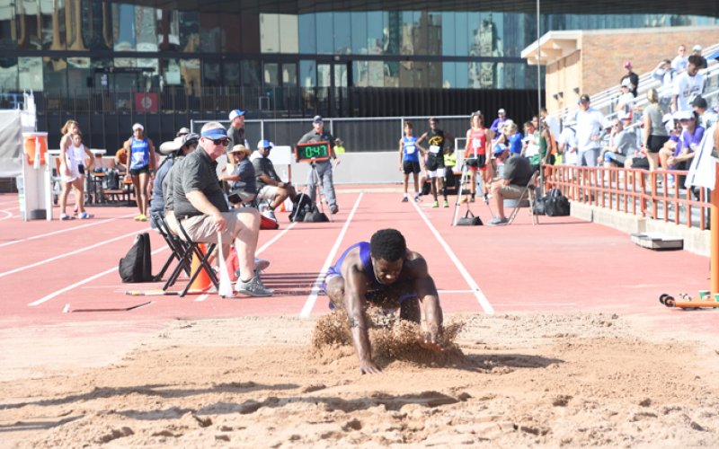 Dalton Brooks splashes down in the pit during the long jump. Photo by Mark Lube.