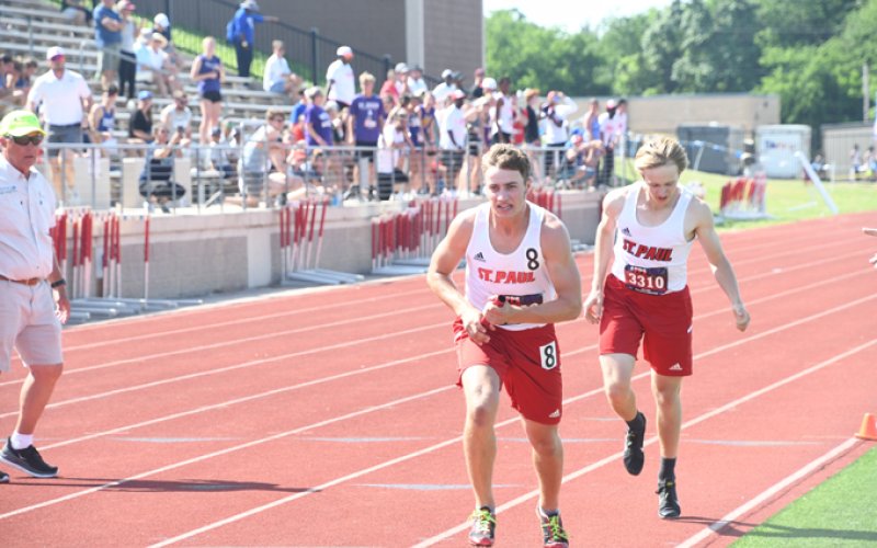 Noah Boedeker takes off after the handoff from Alex Brown in the mile relay. Photo by Mark Lube.