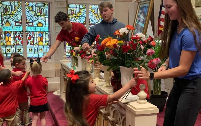 Elementary students present flowers to the high school students at Shiner Catholic School at the May crowning ceremony.