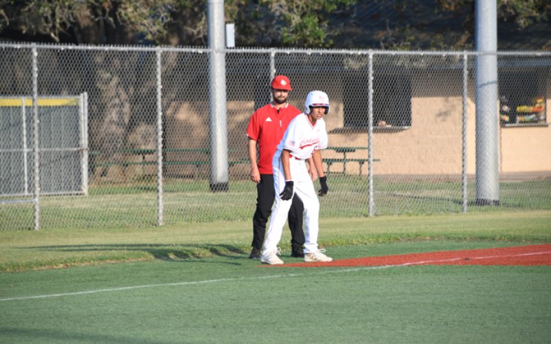 Zeke Rodriguez watches the situation and listens for instructions from head coach Charlie Mieschen. He scored a run in the state semifinals. Photo by Mark Lube