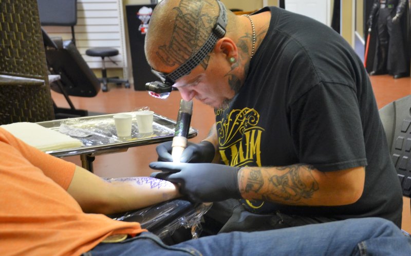 Trey Harris focuses as he begins tattooing a customers forearm June 10.