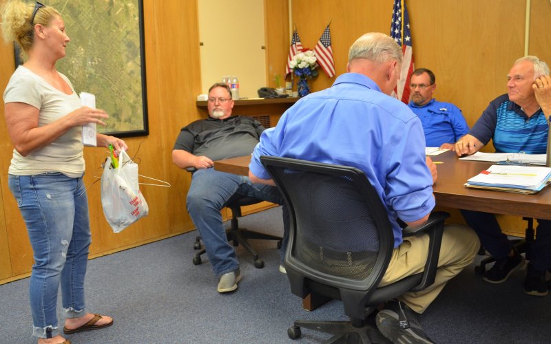 Lisa Kaul presents trash collected at the rodeo arena on Monday, June 13, during last Tuesday’s City Council. Photo by Hans Lammeman.
