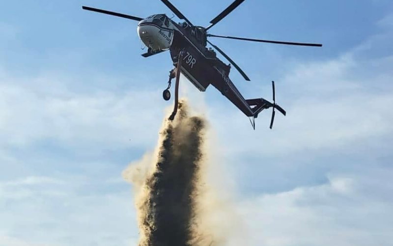 A helicopter releases water to extinguish a large grass fire this week in Colorado County. Photo Courtesy Shiner Fire Department Facebook.