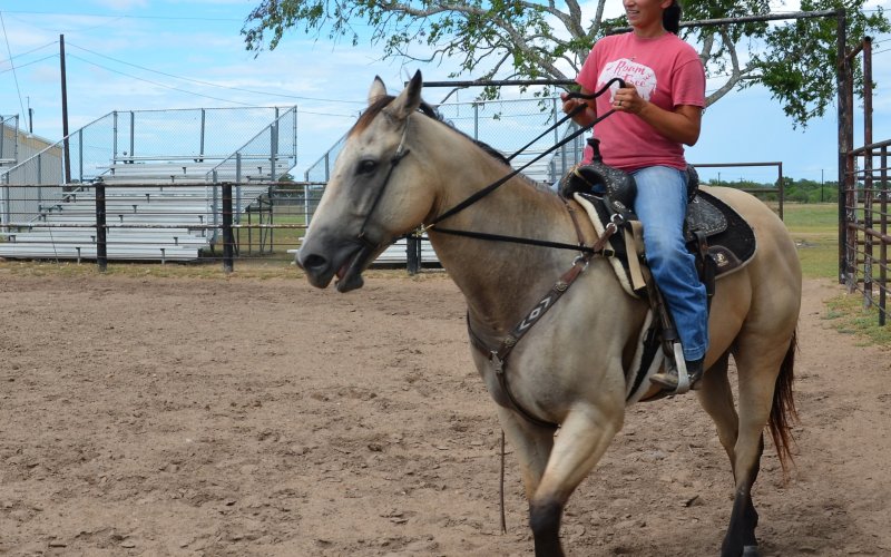 Brittani Richter rides through the Yoakum Rodeo Arena on horseback in July. Photo by Hans Lammeman