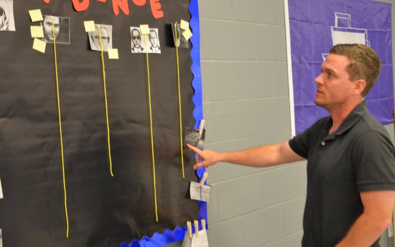 Arron Burnett explains the evidence board displayed in his classroom Aug 16.