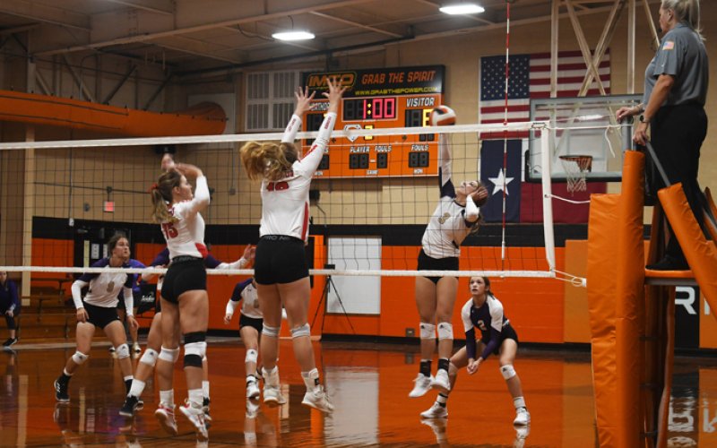 Columbus attempts to block a kill attempt by Chesney Machacek Thursday in the Schulenburg Tournament. Photo by Mark Lube.