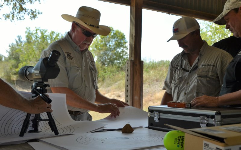 Norbert “Buck” Henneke inspects targets after the shooting concluded Sunday.