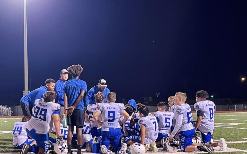 Yoakum YFL coaches discuss adjustments with the 12U Bulldog football team during halftime Nov. 5.  Photo by Hans Lammeman