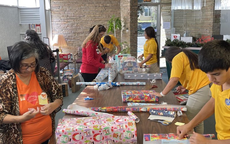 : St. Joseph Catholic School 8th graders wrap gifts at the DLSEC building in Yoakum last Thursday.