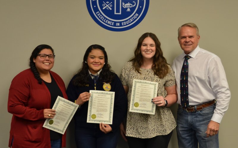 (From left) Adriana Bridges, Jenny Lopez, Laura Johnson and Yoakum ISD School Board President Glen Kusak pose during the Dec. 12 YISD board meeting.  Photo by Hans Lammeman.