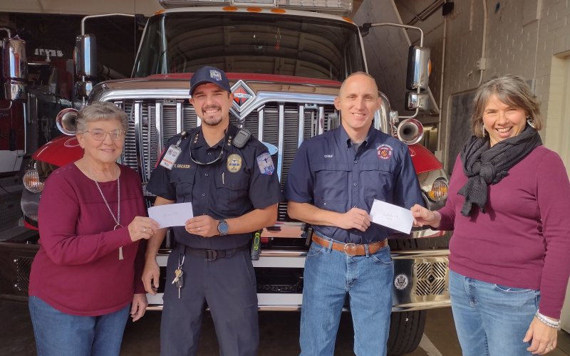 Wied member, Mary Pustka presents check to Shiner VFD representative, Tim Decker. Fire Chief, Steven Grahmann of Hallettsville VFD receives check from Wied vice president, Diane Aschen.