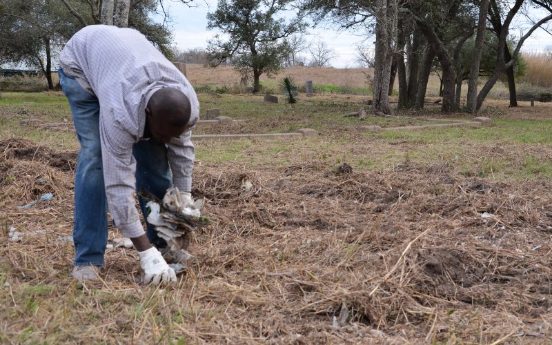A Yoakum Memorial Association volunteer collects litter from the Yoakum City Colored Cemetery on Wednesday, Jan. 25.