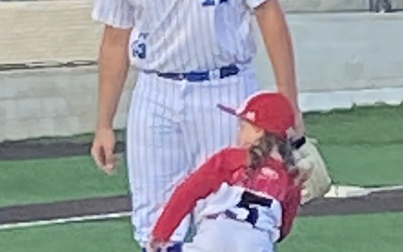 Quinn Janak throws out the first pitch for Sacred Heart vs. St. Paul baseball game.