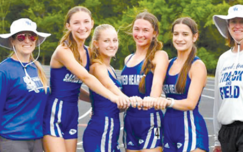 With coaches Jennifer Loudon, left and Wanda Orsak, are the three relay teams that won first in district. From left, Elena Grahmann, Katie Kostelnik, Bailey Haas and Aleigh Kraatz. Chuck Grafe/Tribune-Herald