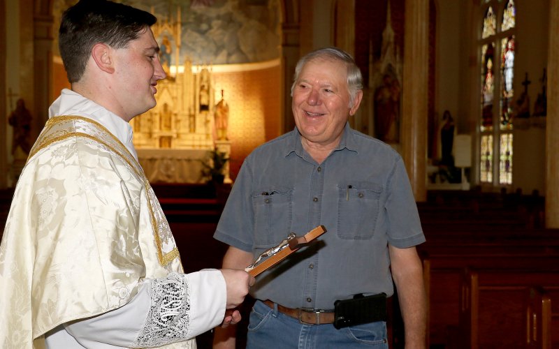 Using wood from the old Shiner church steeple which he got during one of the church's renovations, Harvey Picha constructed a crucifix for Ryan Kapavik.-to-be