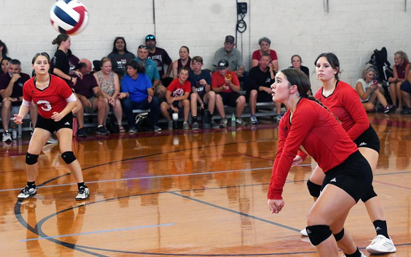 Faith Brown (middle) sets up for a defensive play with Karis Barta (left) and Reese Seibert (right) backing up during a St. Paul JV match against Flatonia on Aug. 15.. Photo by Mark Lube.