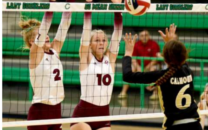 The Halatas (not sisters) Alaina Halata (2) and Grace Halata go up for a block against Calhoun. Chuck Grafe/Tribune-Herald