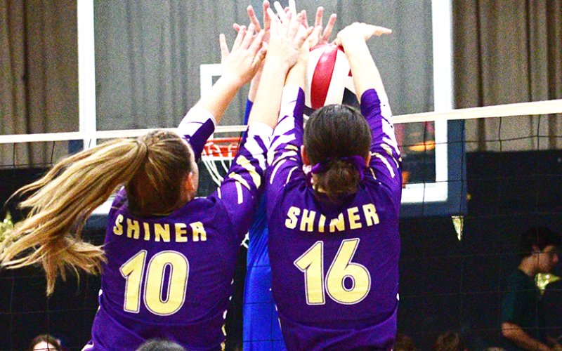 Chelsea Whiddon (left) and Morgan Lenehan (right) perform a double block at Hallettsville Sacred Heart on Aug. 22. Photo by Chuck Grafe/Hallettsville Tribune-Herald.