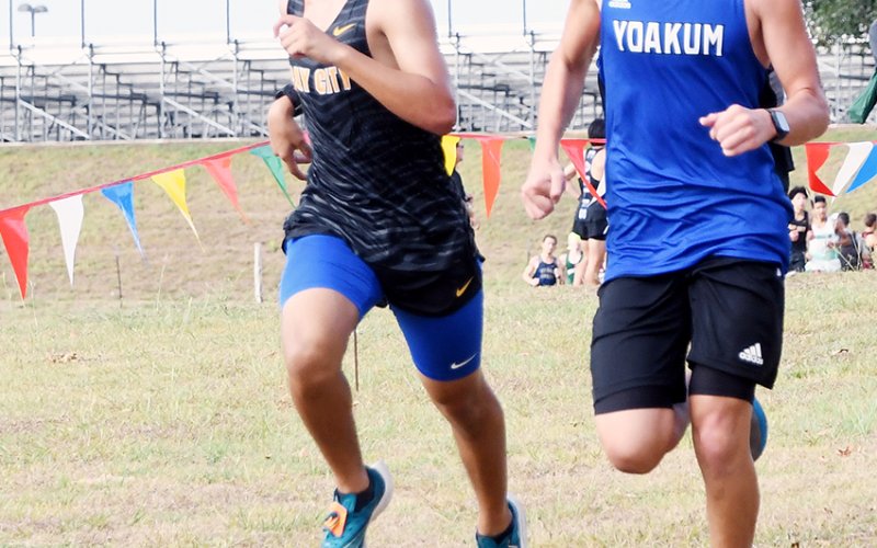 Clayton Hlavac goes to toe-to-toe with a runner from Bay City. Hlavac was No. 31 in 19:57.17. Photo by Mark Lube