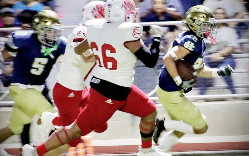 Zeke Basquez (66) and a teammate chase down a Holy Cross ball carrier Friday night in San Antonio. Photo courtesy of Brian and Louann Heinsohn.