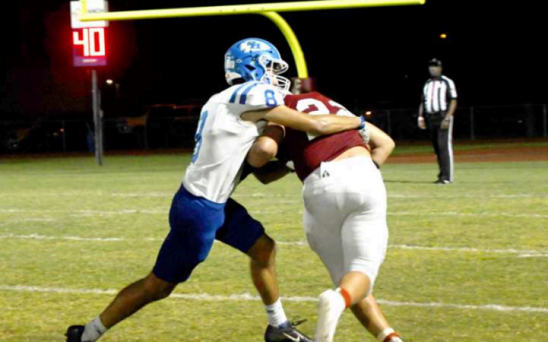 Nic Angerstein collars St. Paul Cardinal halfback Nate Boedeker. Mark Lube/Shiner Gazette