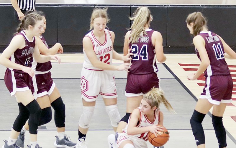 Dallyn Pesek takes a seat on the floor to claim the ball and then looks for open teammate in the Lady Cards’ Fayetteville Tournament game against Flatonia. Sloane Kocian is also in on the play. Photo courtesy of Louann Heinsohn.