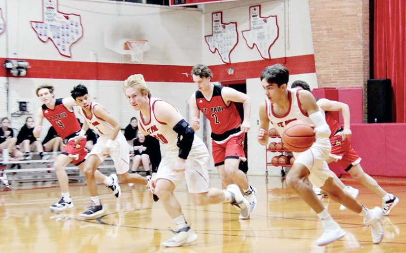 St. Paul player Zeke Rodriguez (far right) moves the ball down court with teammates Zane Barta (middle) and Andrew Nunez (second from left) move with him in support. Alumni players Joseph Twyford (second from right) and Jacob Wachsmuth (left) give pursuit. Photos courtesy of Louann  and Brian Heinsohn.