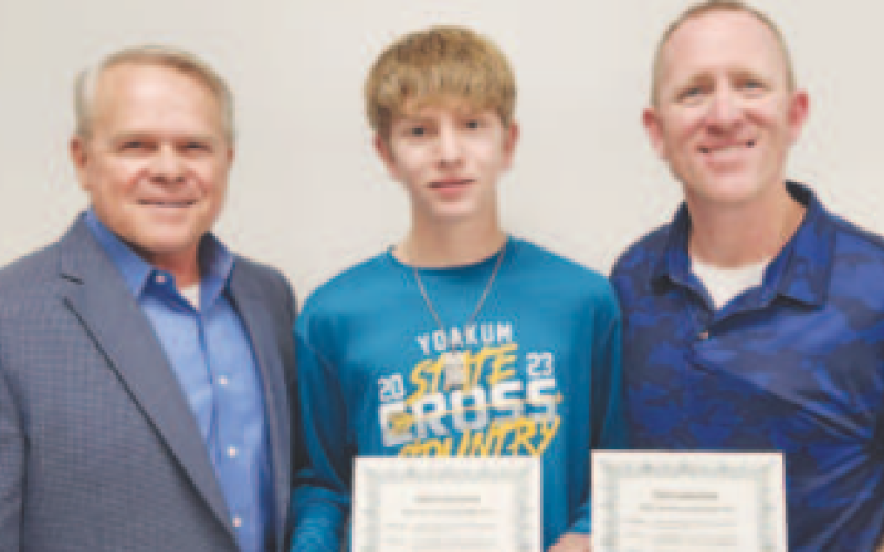Pictured in the center is YHS Cross Country student athlete Aiden Alvarez. He ran in the State Cross Country Meet in Austin. Pitcured at left is President Glen Kusak. Pictured at right is Coach Dennis Muehlstein.