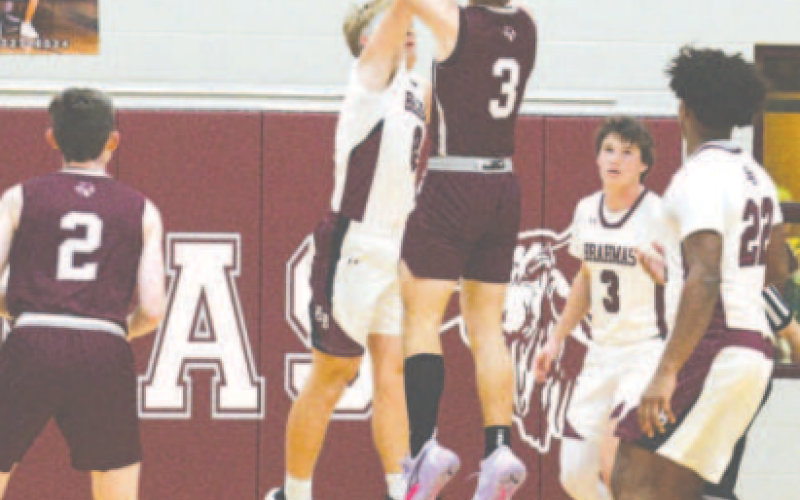 Nathan Henke blocks a shot by Industrial’s Hunter Halepaska. Chuck Grafe/Tribune-Herald