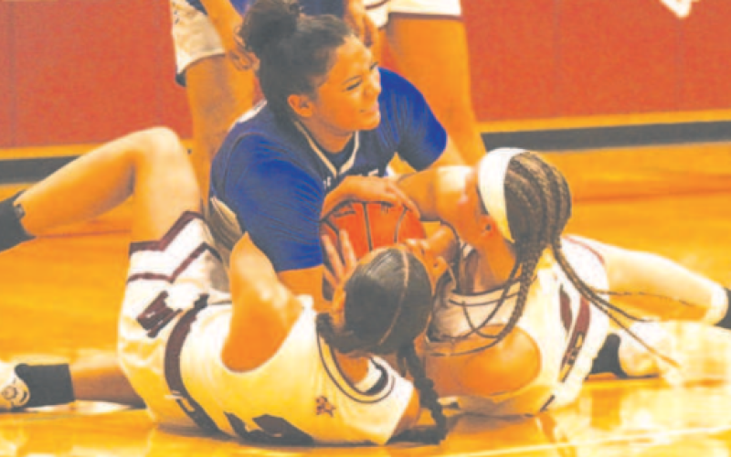 Kasey Harper, left, and Layten Kolacny get in a battle with Edna’s Shanti Guerra in the third period of the game here Friday night. Chuck Grafe/Tribune-Herald