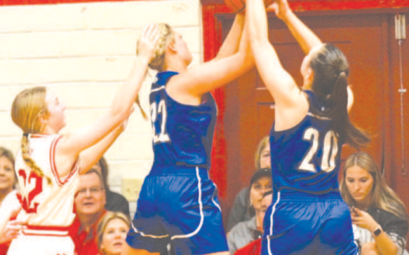 Kaycee Schindler (22) and Ava Lackey (20) grab a rebound during the victory over St. Paul. Chuck Grafe/Tribune-Herald