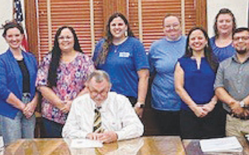 Members of SJRC Texas-Belong receive a proclamation from DeWitt County Commissioners declaring April 2024 as National Child Abuse Prevention Month. DeWitt County Judge Daryl Fowler, center, signs the proclamation at the March 25 meeting.