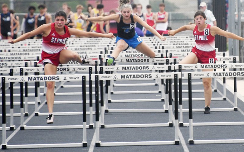 Petra Kock (left) and Gabby Rodriguez (right) leap over the hurdles during the 100-meter hurdles event Friday in the TAPPS South Regional track meet in Seguin. Koch was second with 17.48 seconds and Rodriguez came in seventh place.  Photo by Mark Lube.