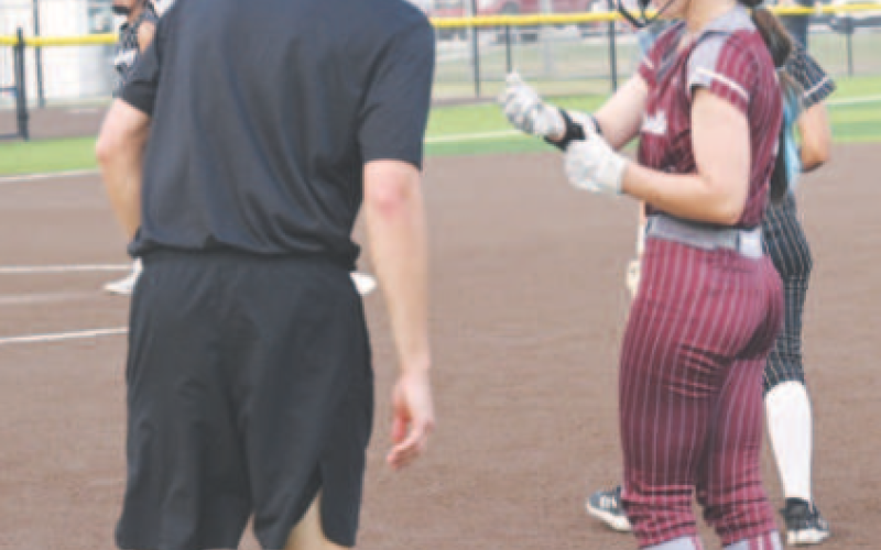 Hanna Zachary chats with assistant coach Carson Schindler after Hanna singled. Chuck Grafe/Tribune-Herald