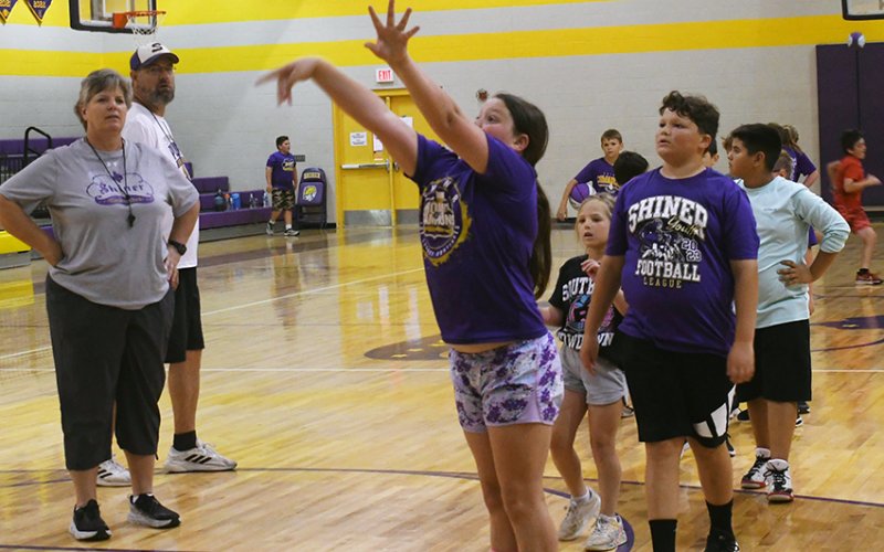 Campers work on shooting under the watchful eyes of Peterson (head girls coach) and Jeff Akin (head boys coach). Photo by Mark Lube.