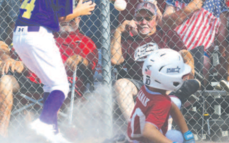 Chans Janak scores on a wild pitch in an earlier tournament game. Chuck Grafe/Tribune-Herald