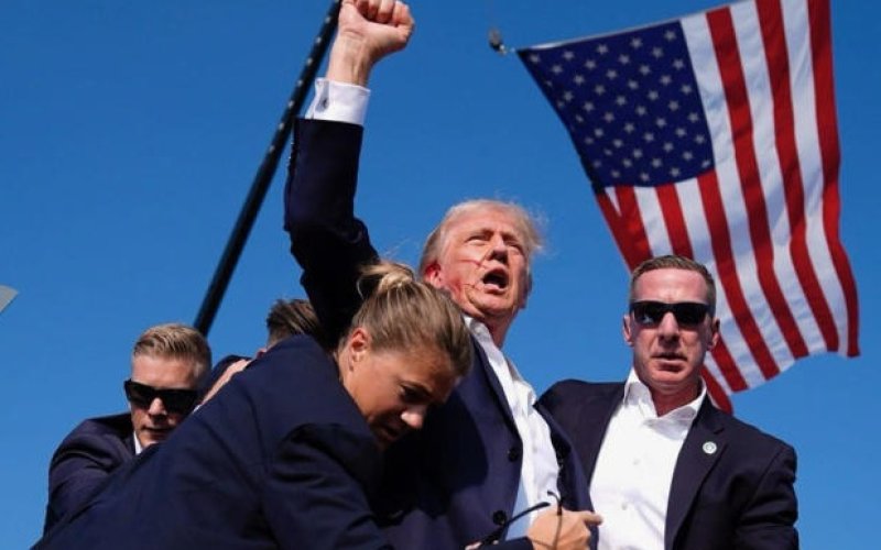 Seconds after a potential assassin’s bullet came within millimeters of former President Donald Trump’s head at a Pennsylvania political rally Saturday, an angry, blood-streaked Donald Trump defiantly raised his fist to the crowd, yelling “Fight. Fight. Fight!” as Secret Service members surrounded him and hurried him offstage to safety.  The shooter, Thomas Matthew Crooks, 20, of Pennsylvania, was gunned down by Secret Service agents. Photo by the Daily Beast
