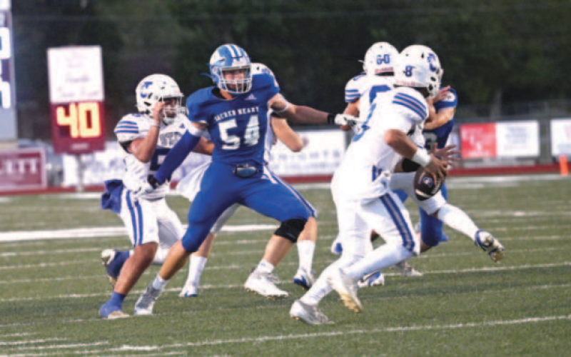 Lance Barton (54) eyes Flyer quarterback Aiden Aragon. Chuck Grafe/Tribune-Herald